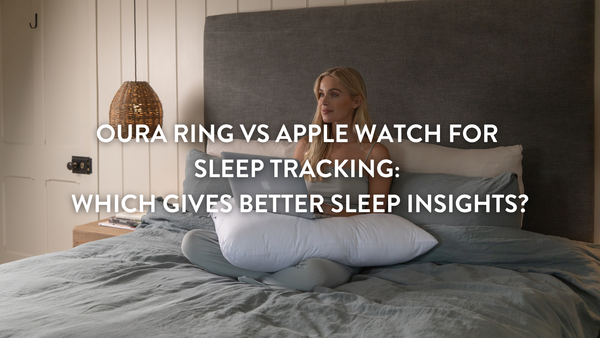 Person sitting up in bed tracking their sleep on a mac book 