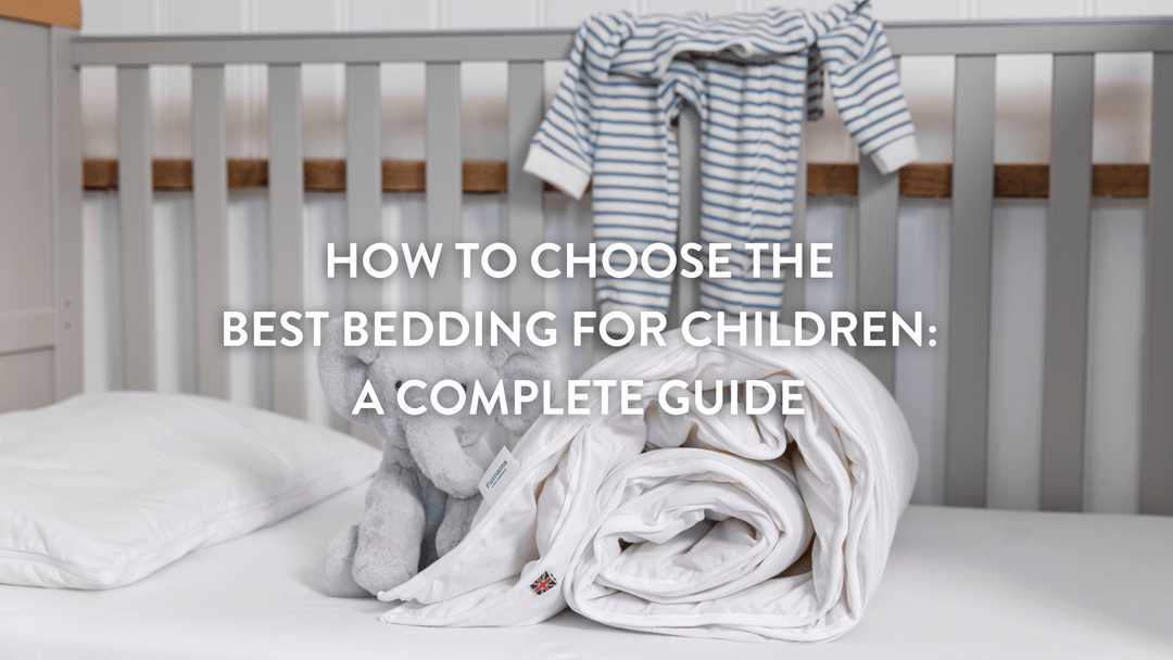 Rolled up children's duvet and cuddly grey elephant on a children's mattress in a cot