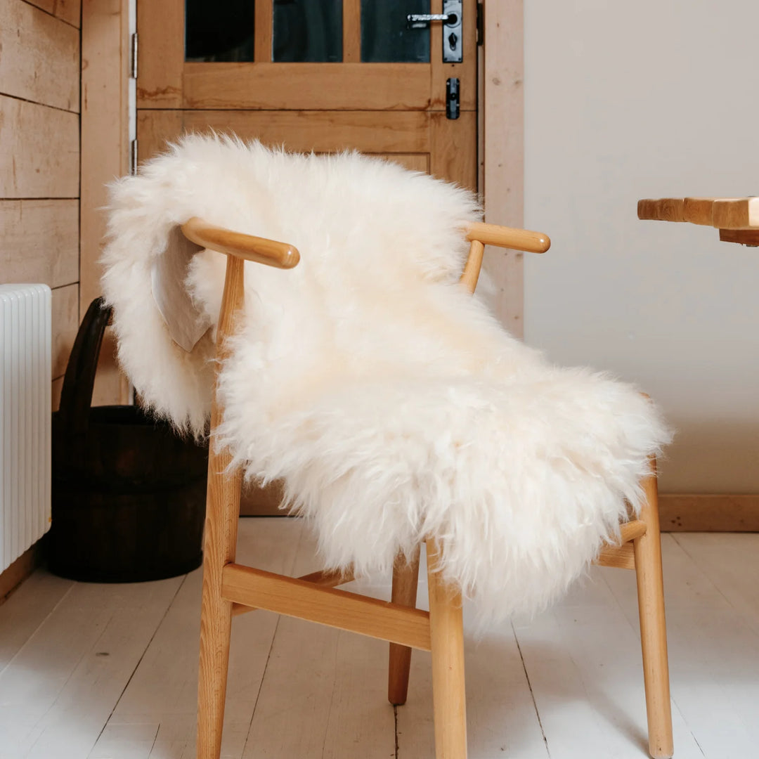 real sheepskin British rug throw cream super soft long pile very fluffy on a chair
