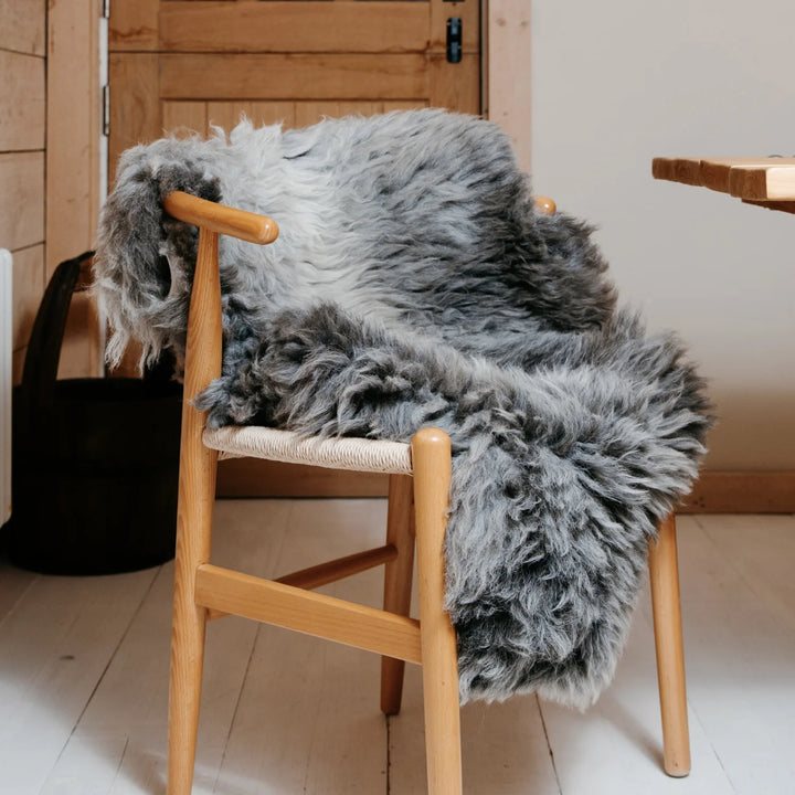 real sheepskin British rug throw grey super soft long pile very fluffy on a chair